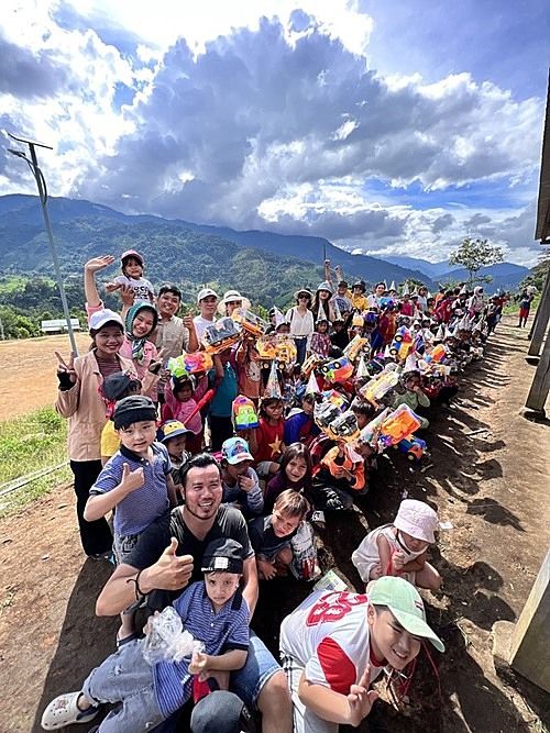 2022年6月23日、クアンナム省の山岳地帯で子どもたちと記念撮影をするリエムさん（前から2人目）　ⓒ VnExpress